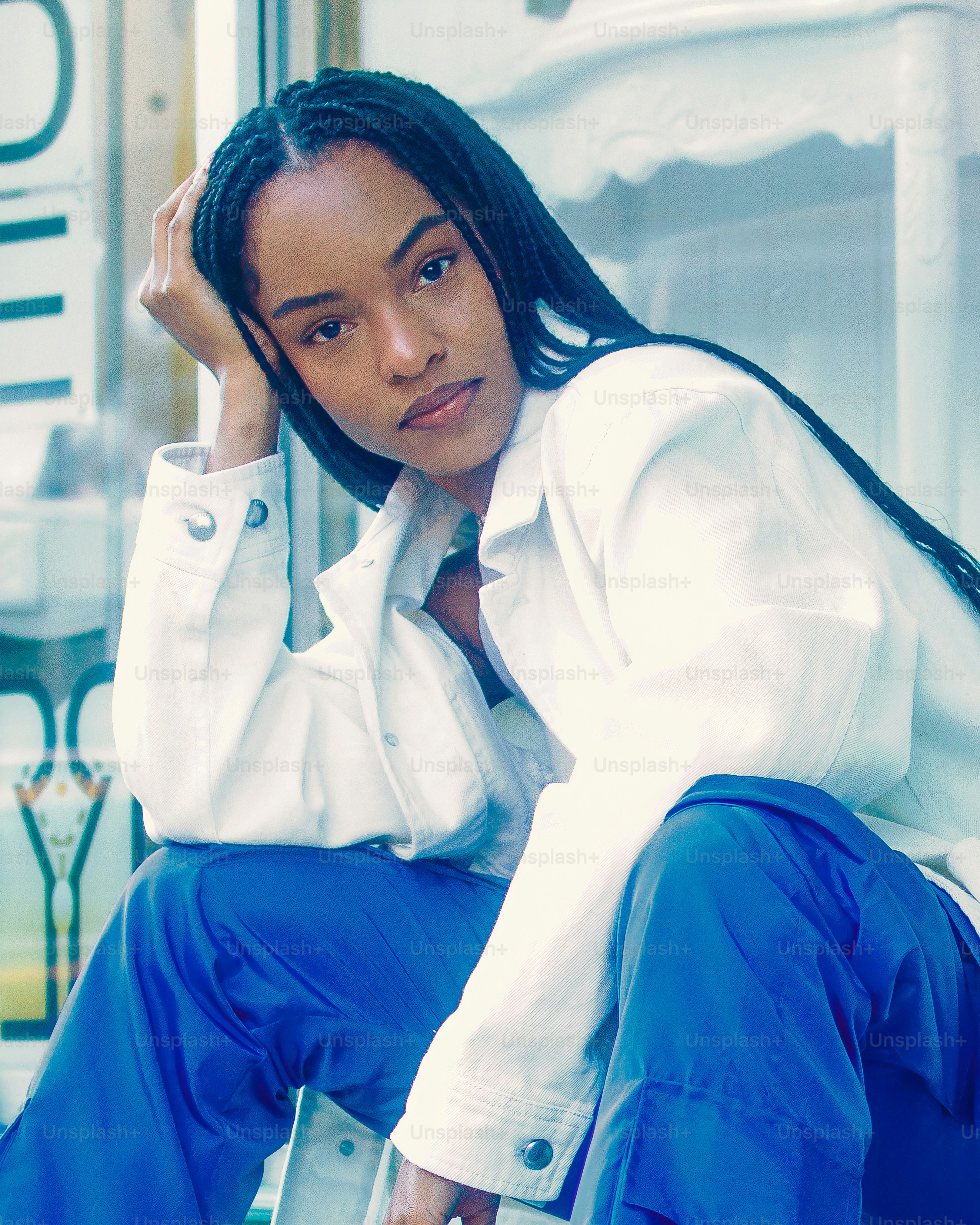A woman in red pants and a white jacket leaning against a wall photo ...