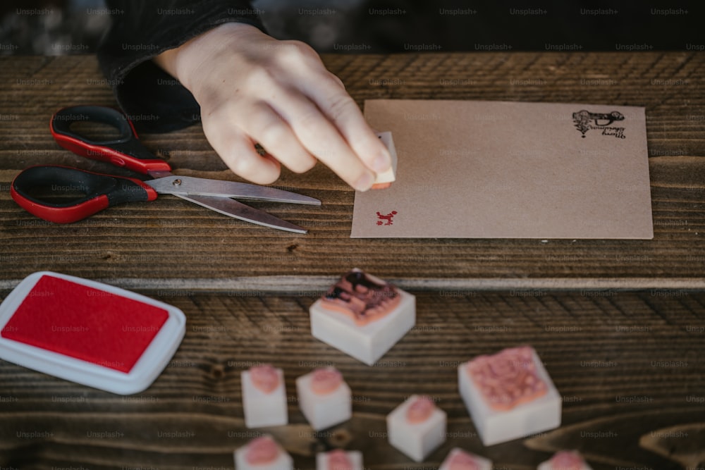 a person cutting a piece of cake with a pair of scissors