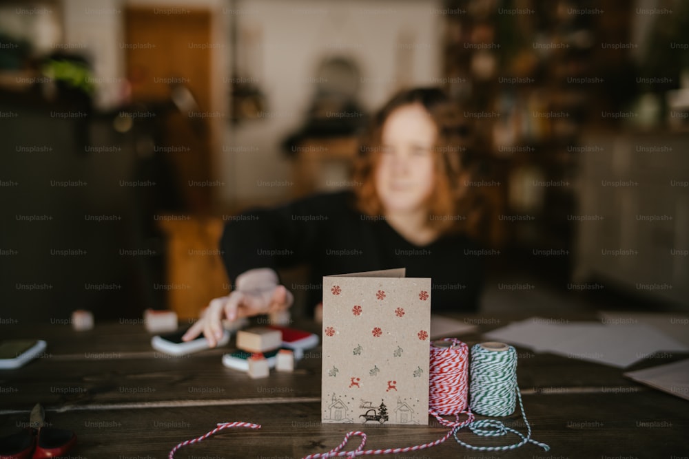 a woman sitting at a table with a box of yarn