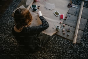 Eine Frau, die an einem Tisch sitzt und auf ihr Handy schaut