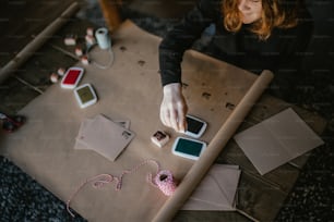 a woman sitting at a table working on crafts