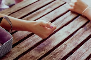 two people sitting at a wooden table holding hands
