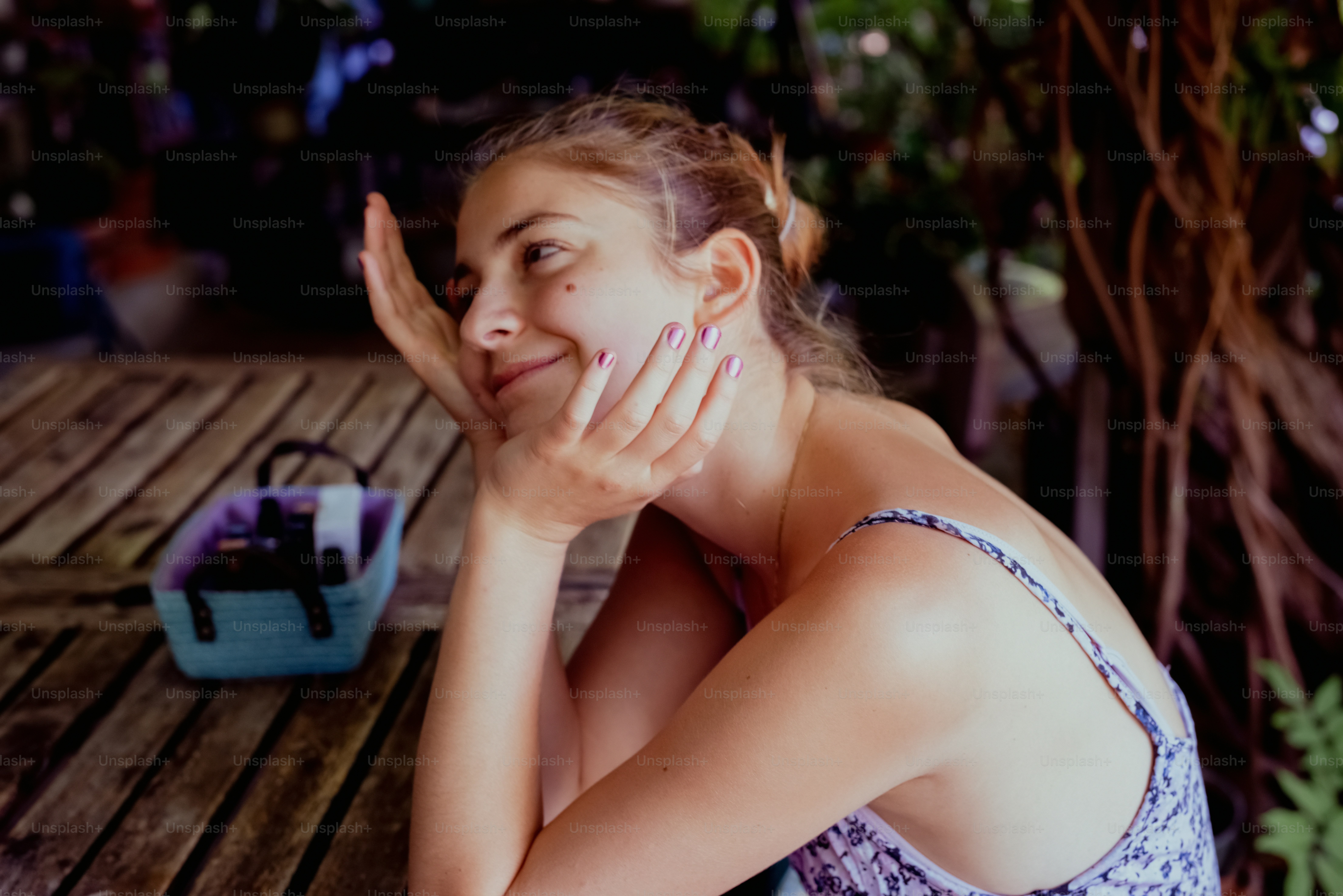 a woman sitting at a table with her hand on her face