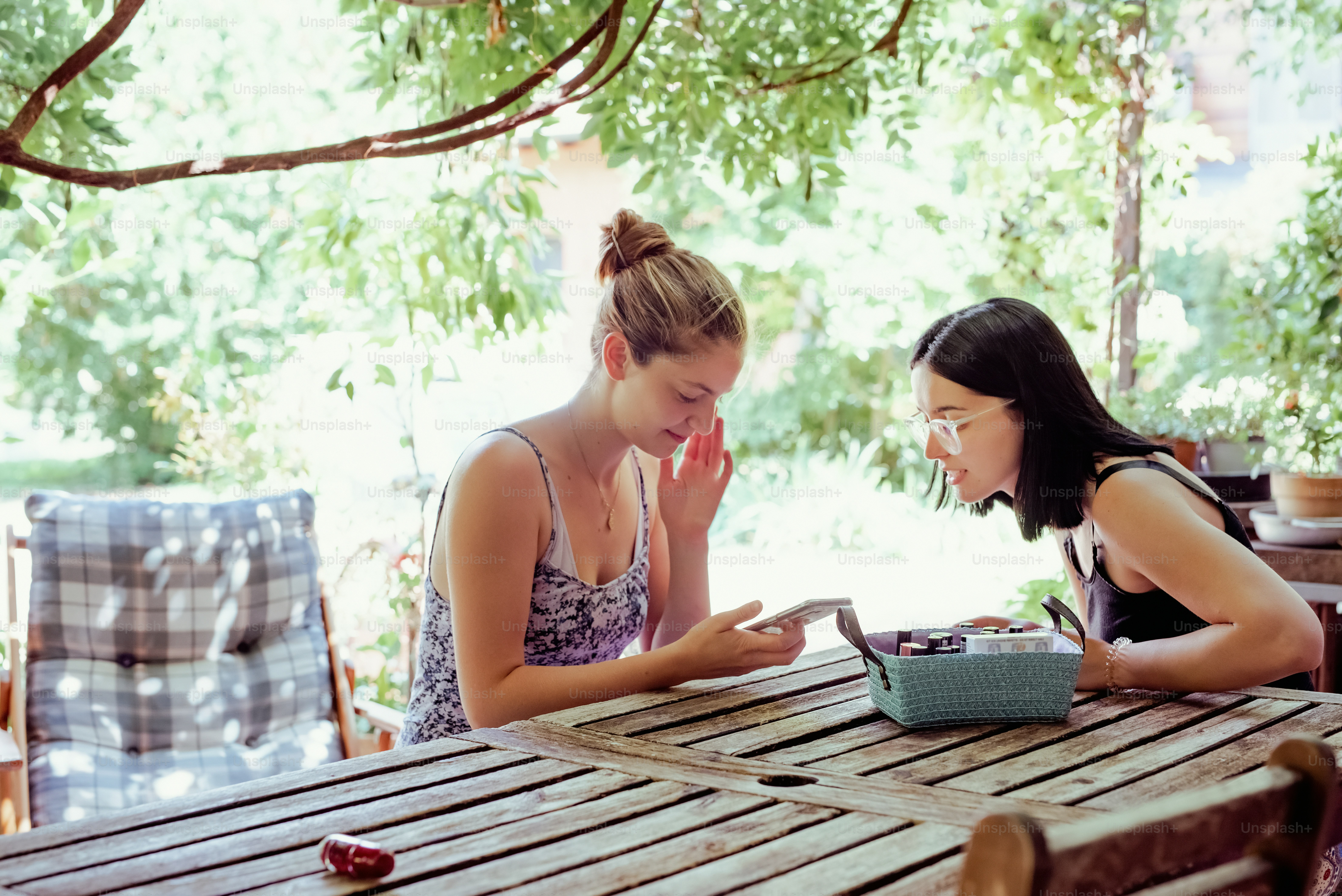 two women sitting at a table with a typewriter