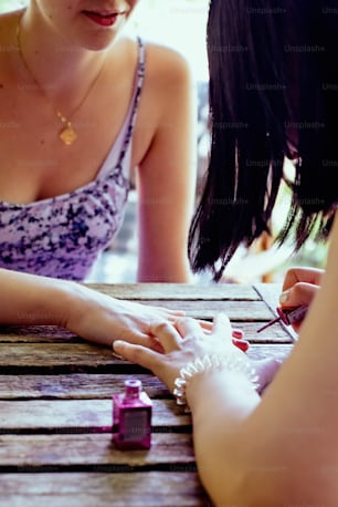 Una mujer sentada en una mesa con un brazalete en la mano