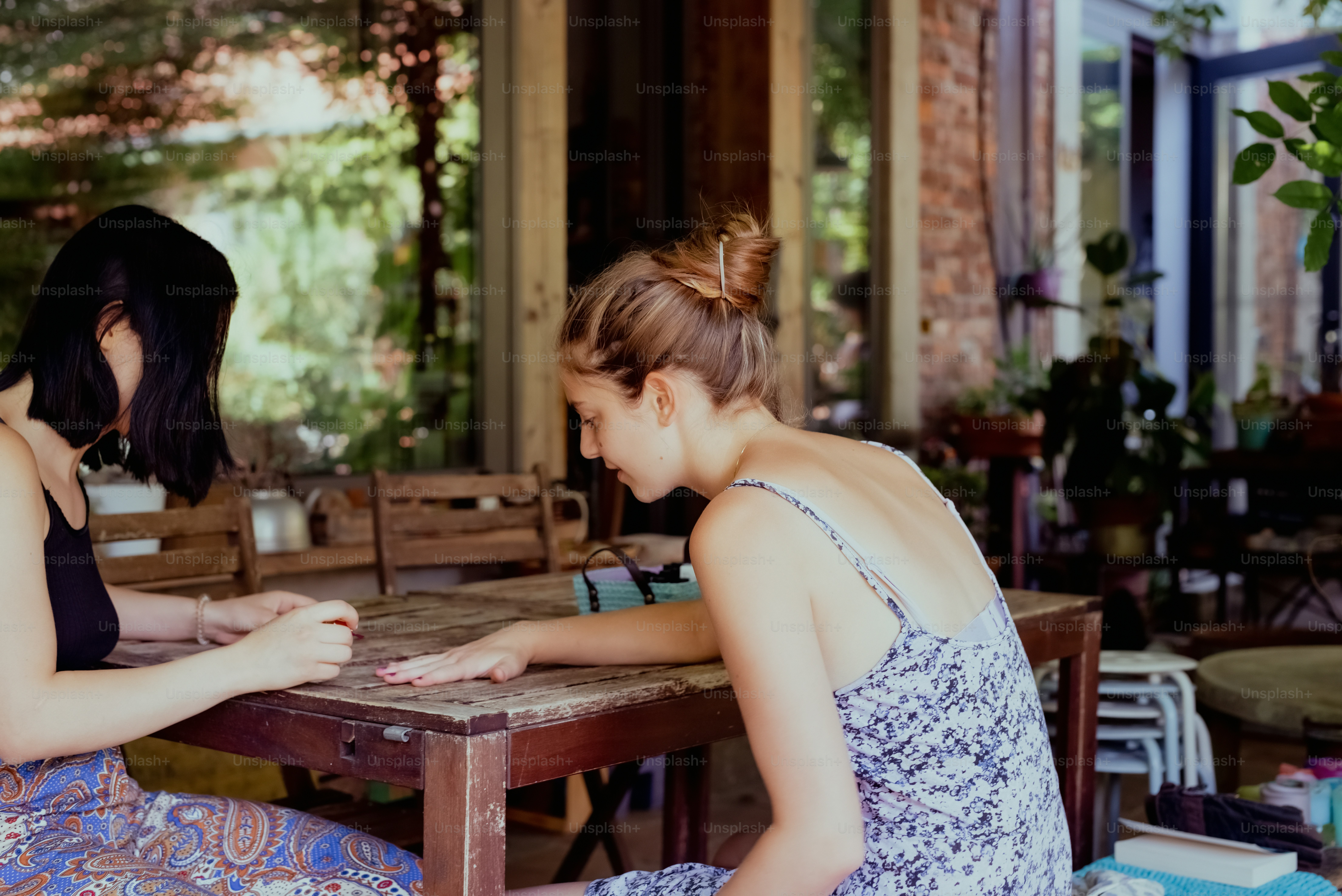 two women sitting at a table playing a game