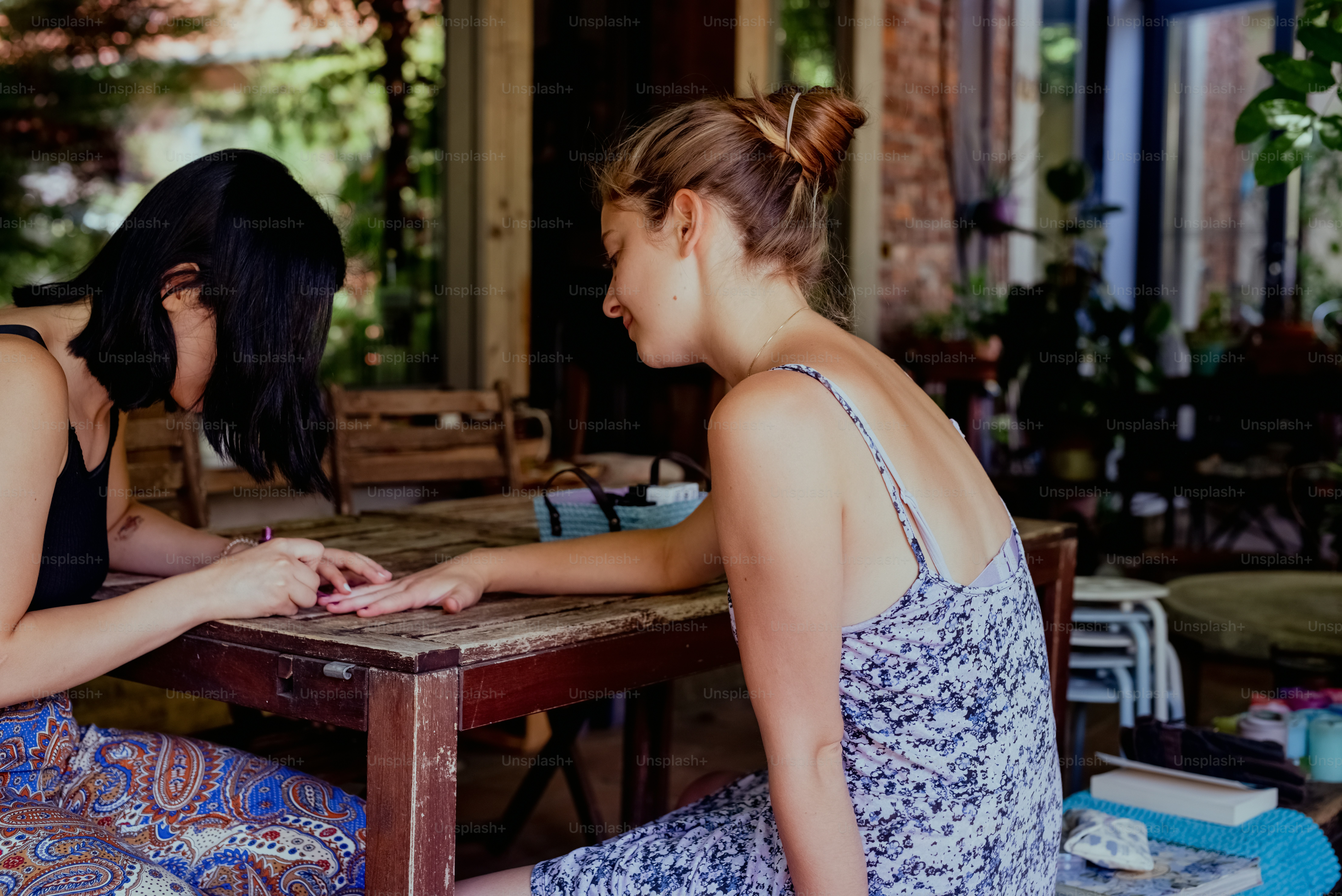 two young women sitting at a wooden table