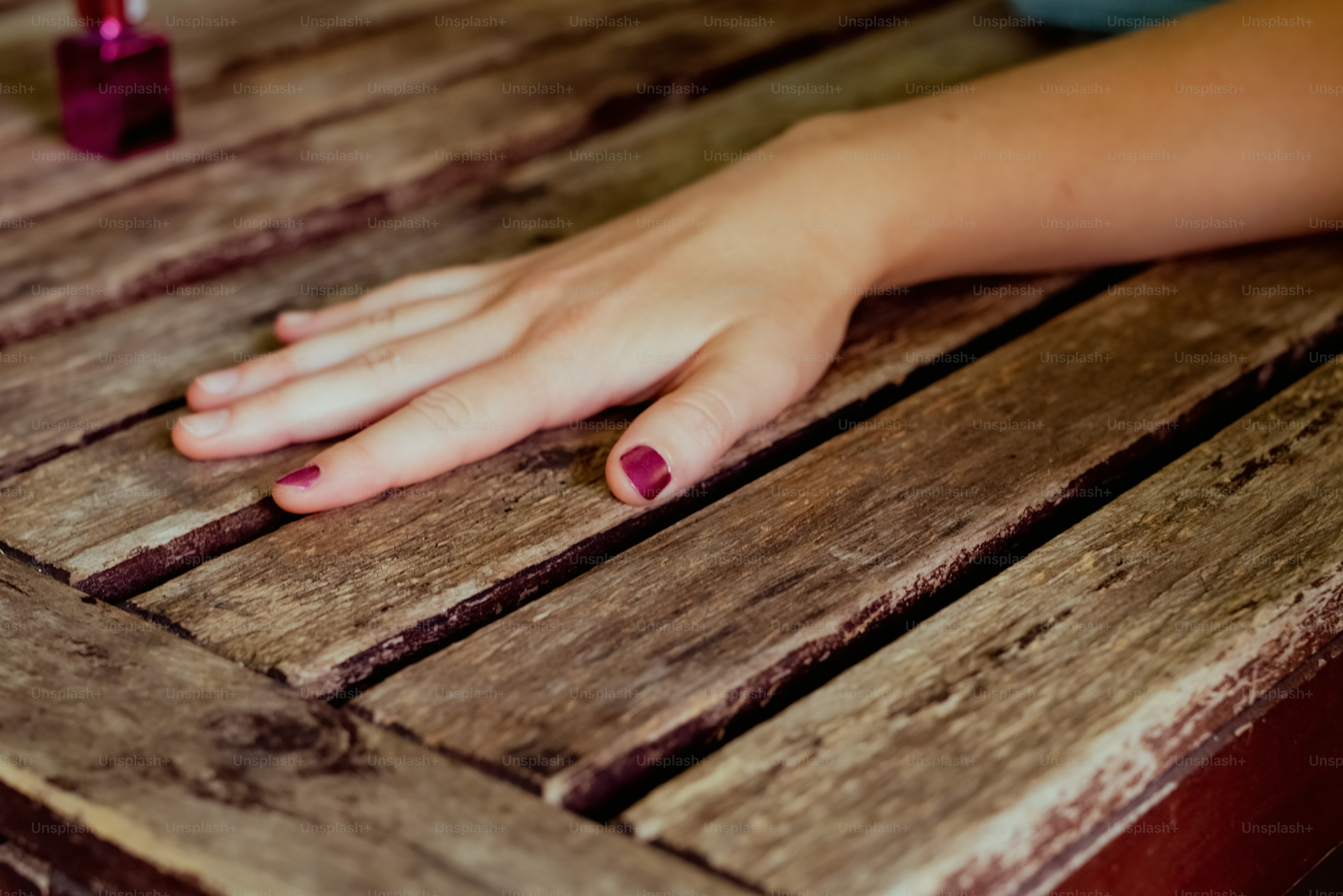 a person's hand resting on a wooden table