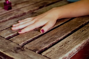 a person's hand resting on a wooden table