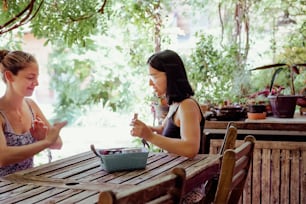 a couple of women sitting at a wooden table