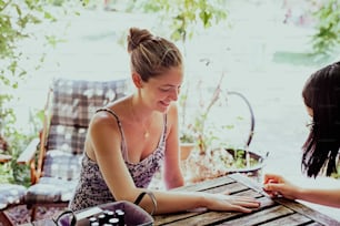 two women sitting at a wooden table together