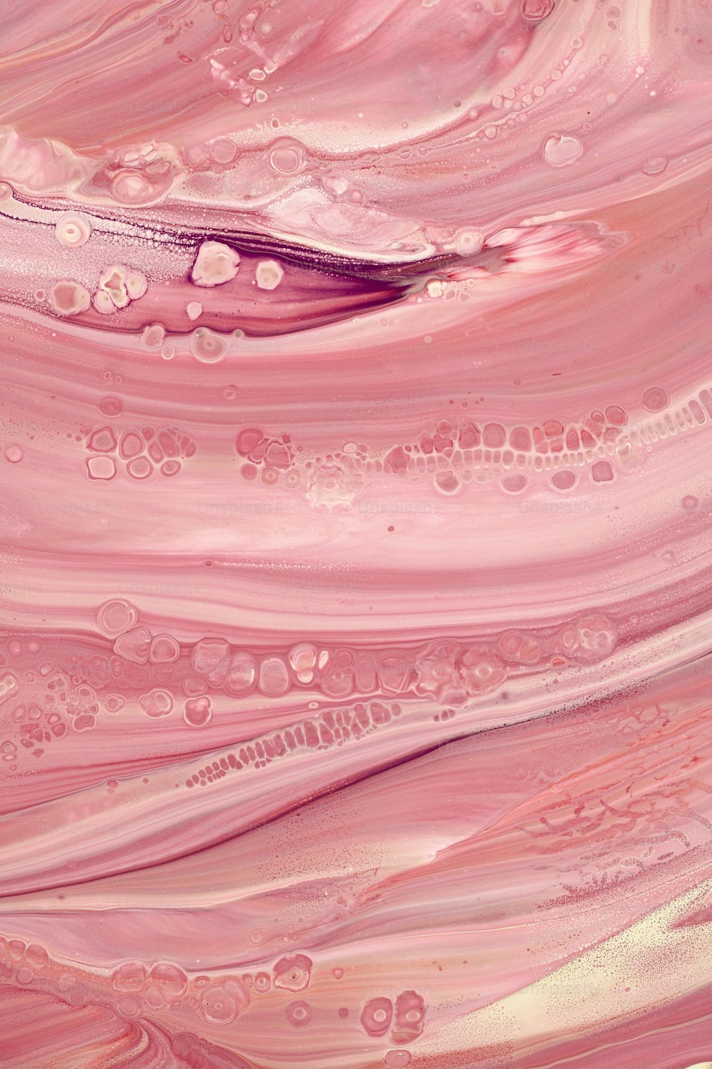 a close up of a pink and gold fluid painting