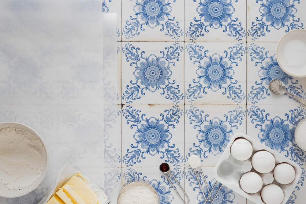 그릇, 그릇 및 식기가 있는 파란색과 흰색 타일 벽