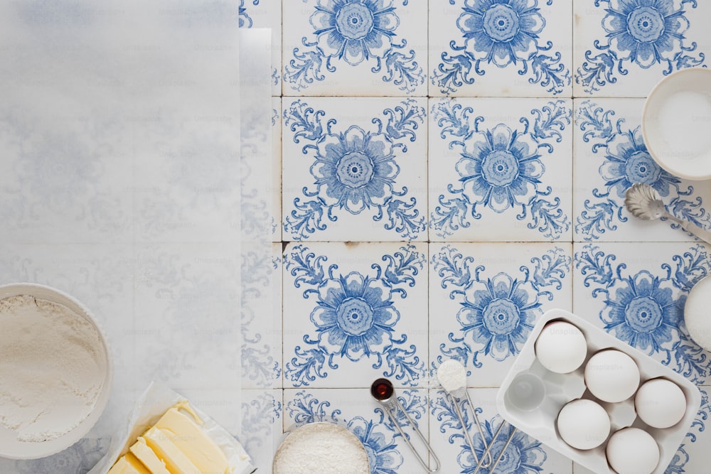 a blue and white tiled wall with bowls and utensils