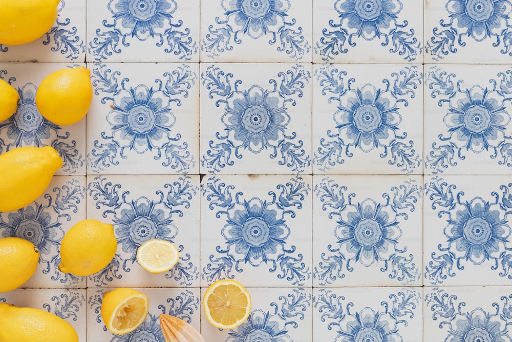 a bunch of lemons sitting on top of a blue and white tile