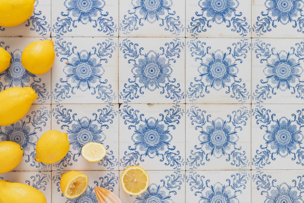 Un manojo de limones sentado encima de un azulejo azul y blanco