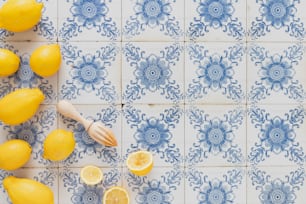 un mazzo di limoni seduti sopra una piastrella blu e bianca