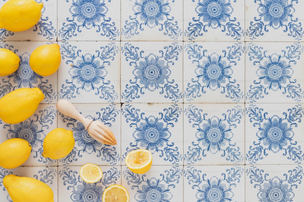 a bunch of lemons sitting on top of a blue and white tile