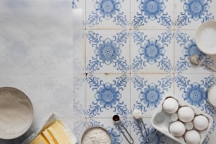 a blue and white tiled wall with bowls, bowls, and utensils