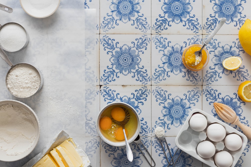 a blue and white tiled counter top with eggs and other ingredients