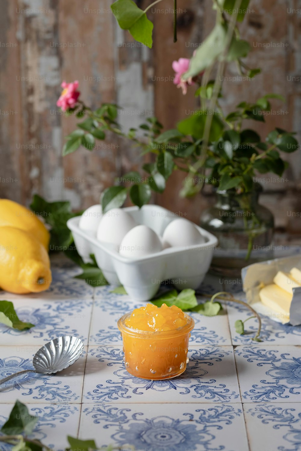 una mesa cubierta con un tazón de naranjas junto a un tazón de huevos