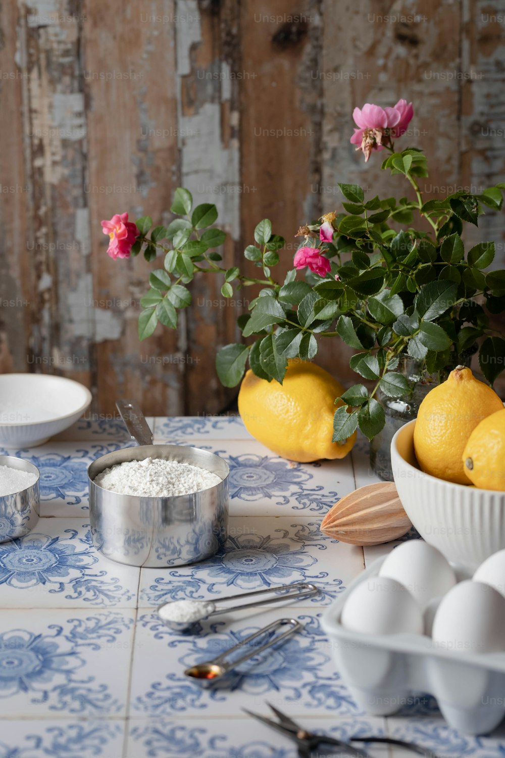 uma mesa coberta com uma tigela de limões ao lado de uma tigela de ovos