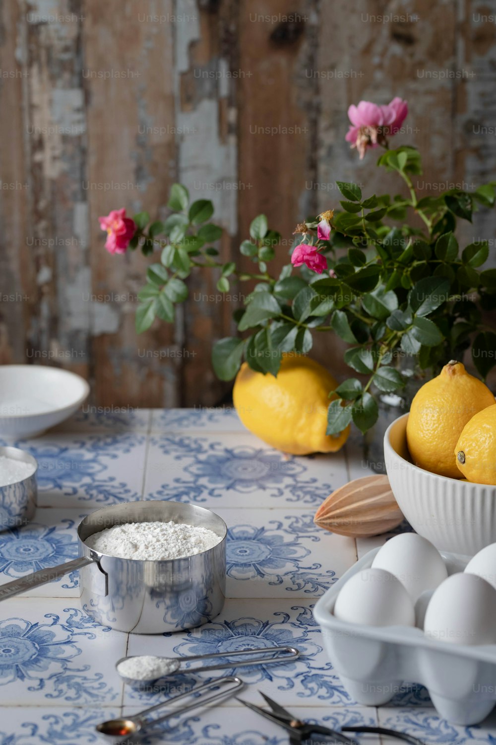 a table topped with bowls filled with lemons and eggs