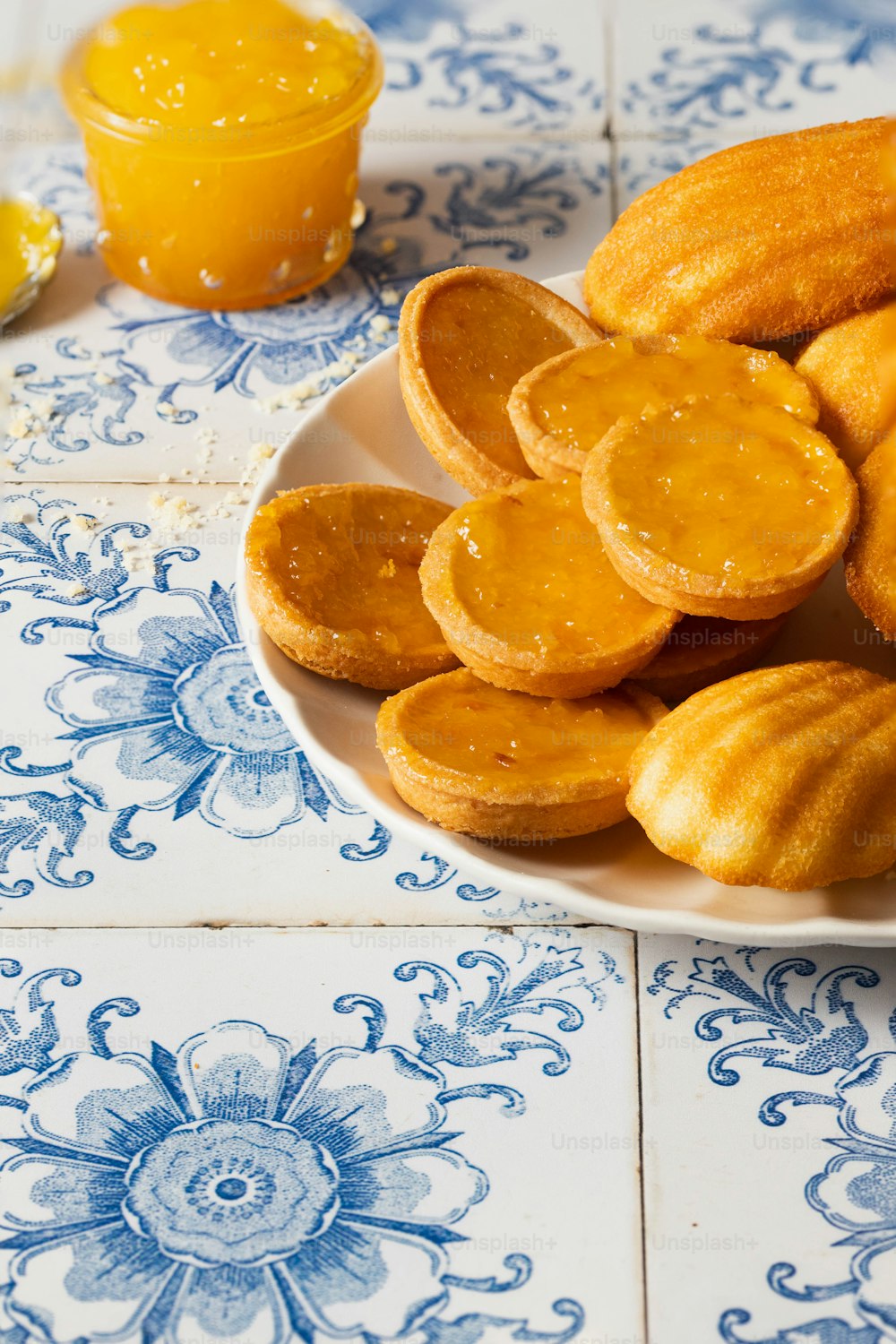 a white plate topped with fried food next to a glass of orange juice