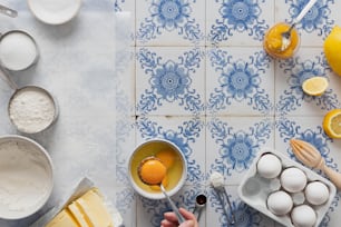 a blue and white tiled counter top with eggs and oranges