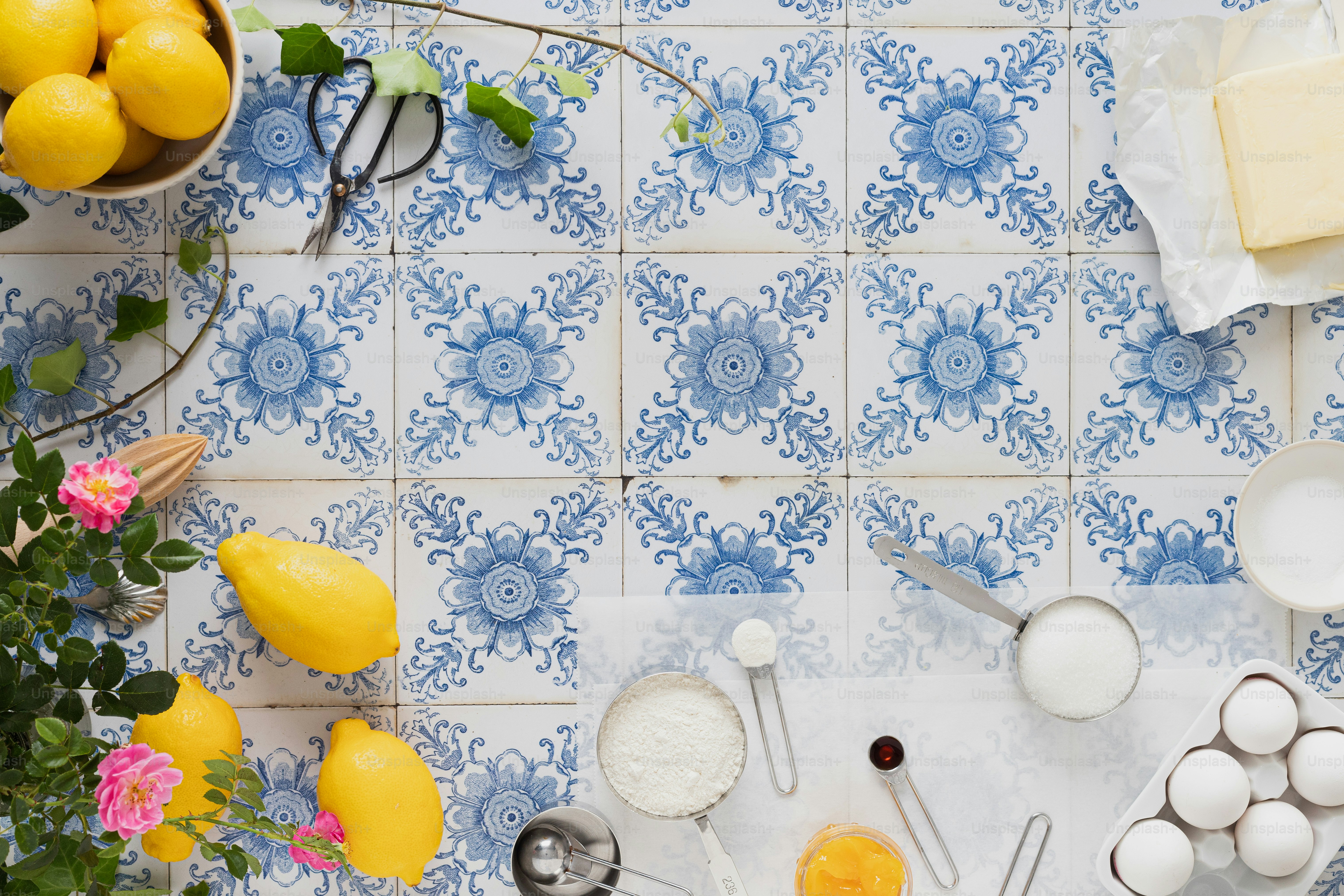 eine blau-weiße Fliese mit Zitronen, Eiern und Utensilien