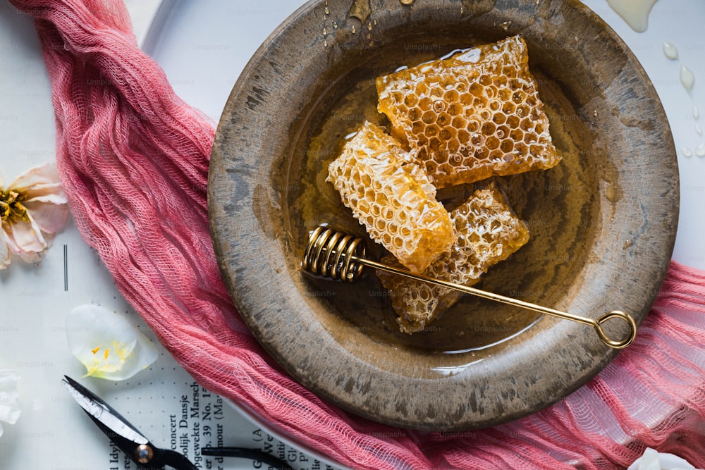 un bol rempli de miel sur le dessus d’une table