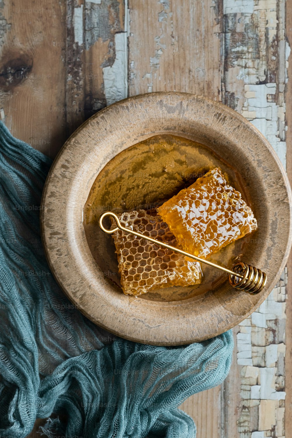 a wooden bowl filled with honey and a honey comb
