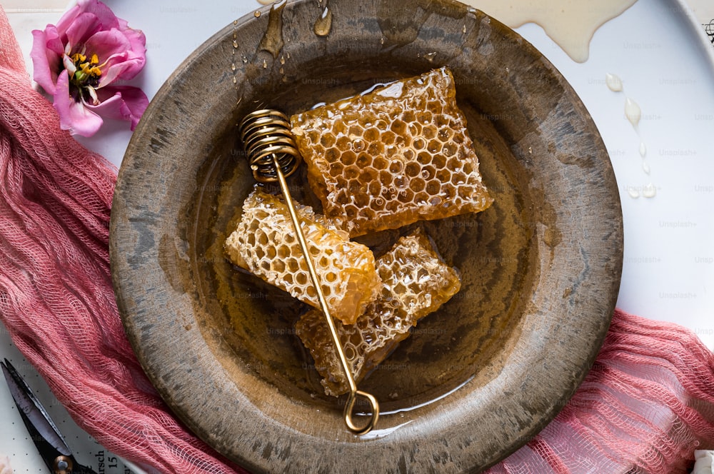 uma tigela de madeira cheia de favos de mel em cima de uma mesa