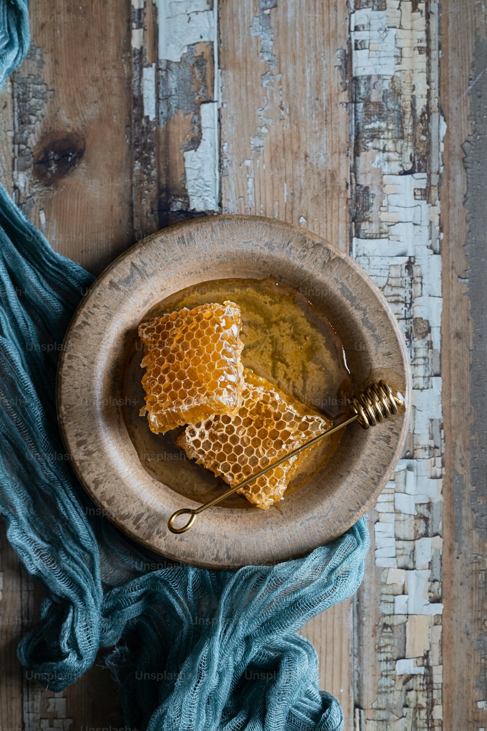 un cuenco de madera lleno de miel encima de una mesa de madera
