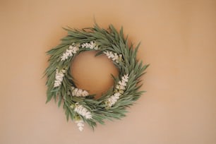 a wreath with white flowers and green leaves