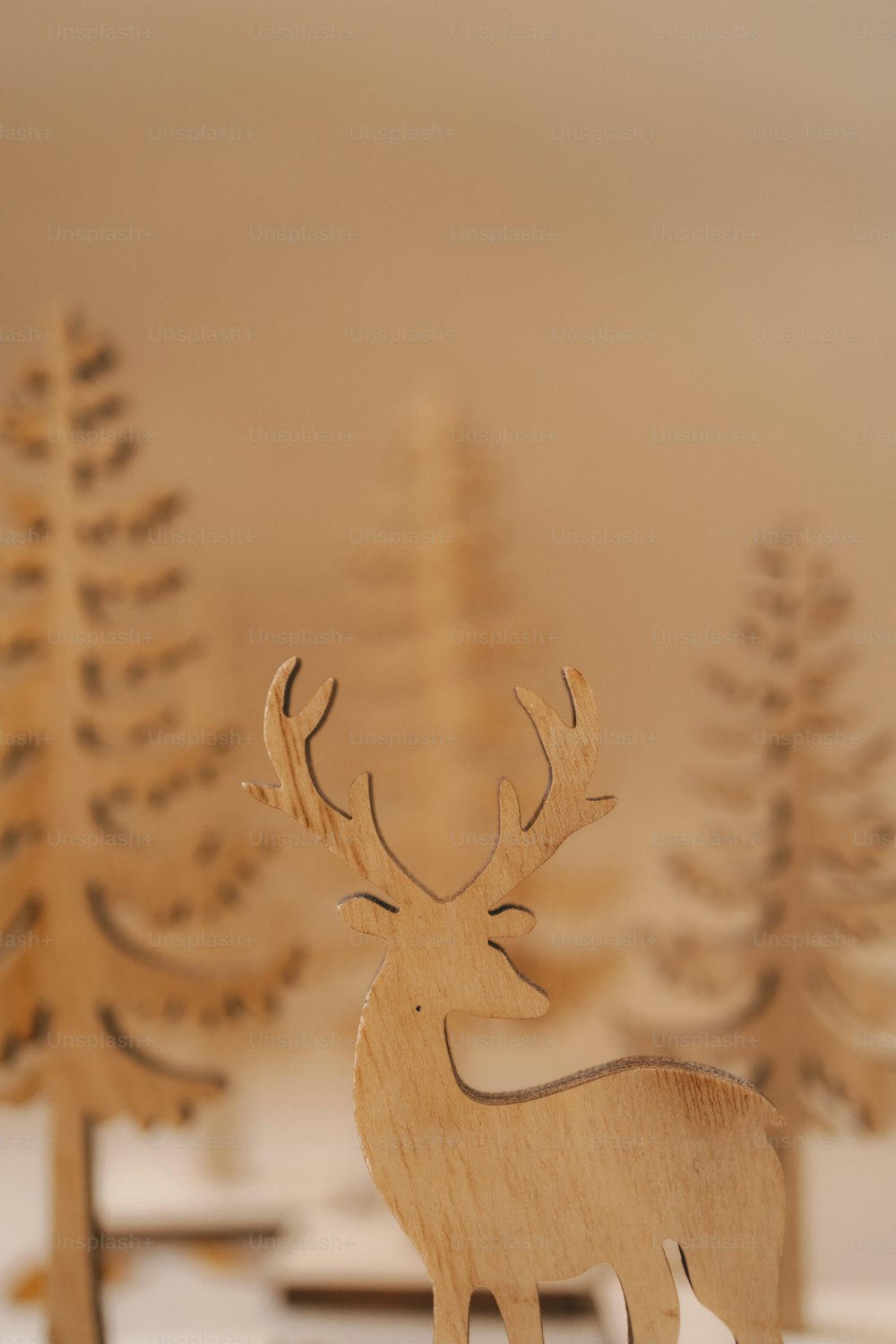 a wooden deer standing in front of some trees