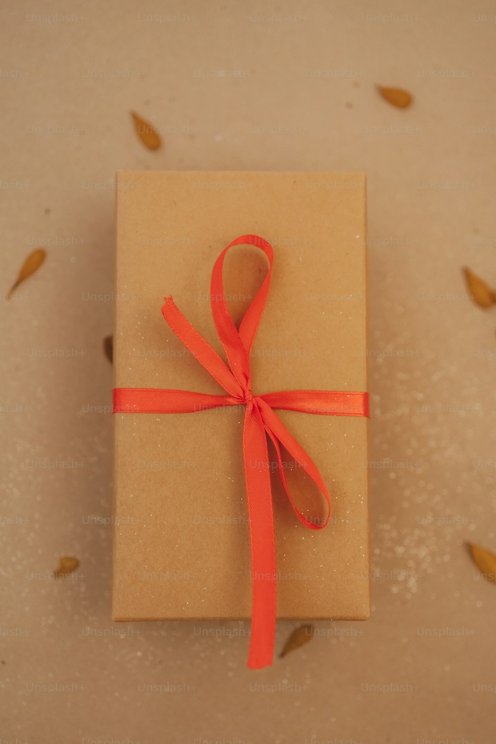 a wrapped gift with a red ribbon on a table