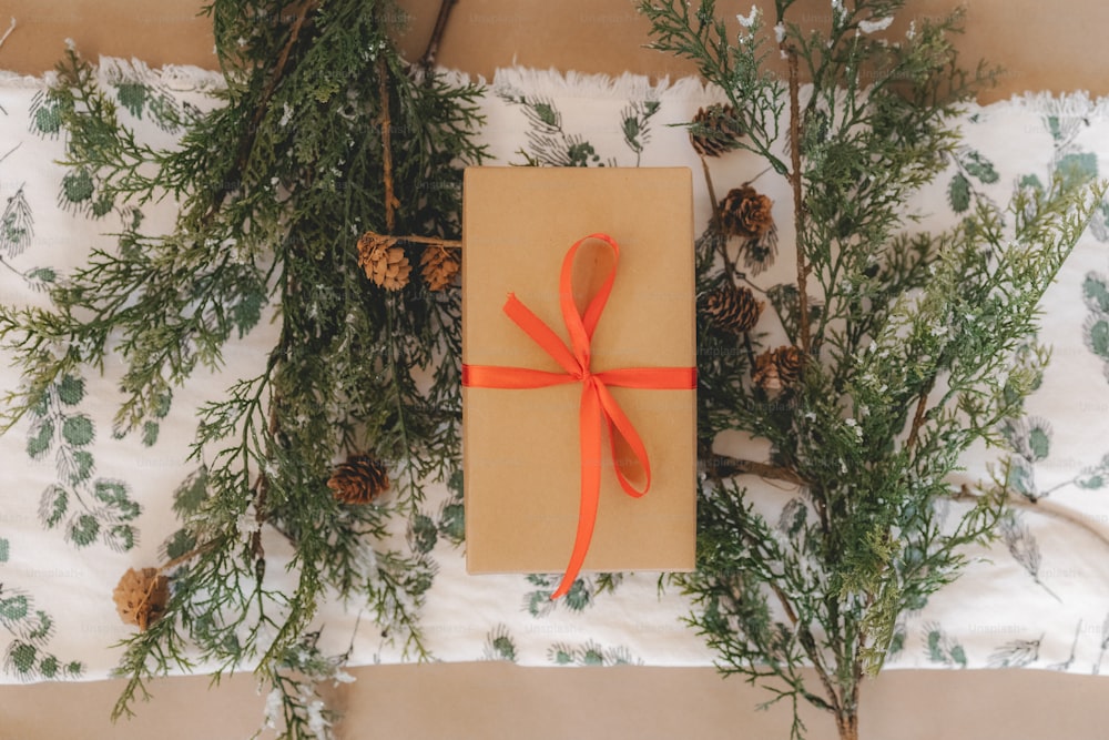 a present wrapped in brown paper with a red ribbon