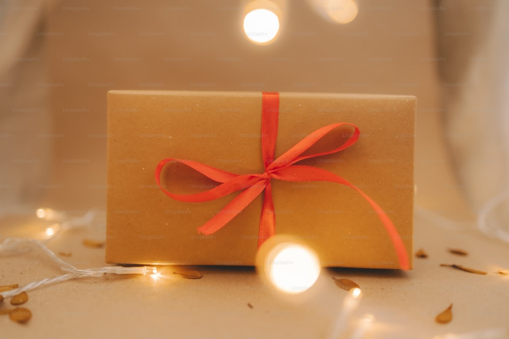 a brown box with a red ribbon on a table