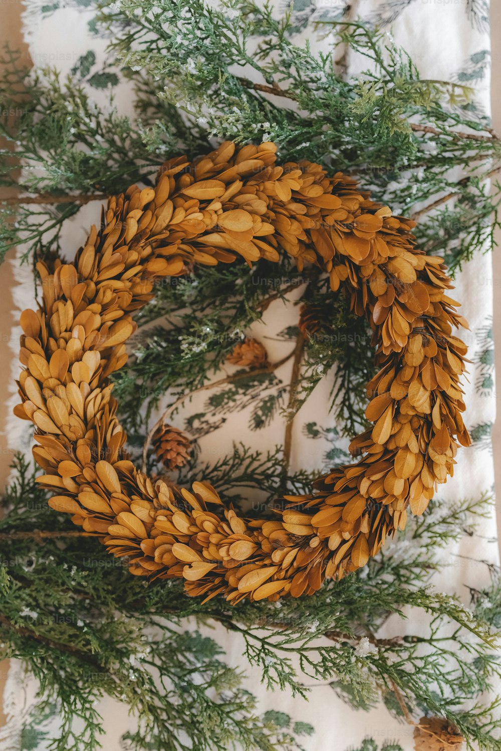 a wreath made out of pine cones and evergreen needles