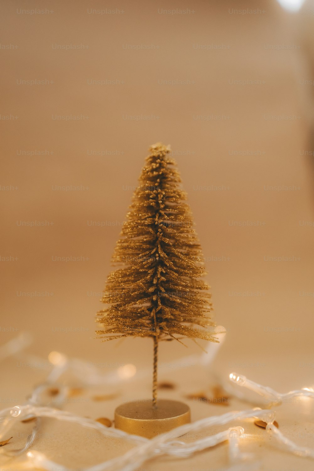 Uma pequena árvore de Natal dourada sentada em cima de uma mesa