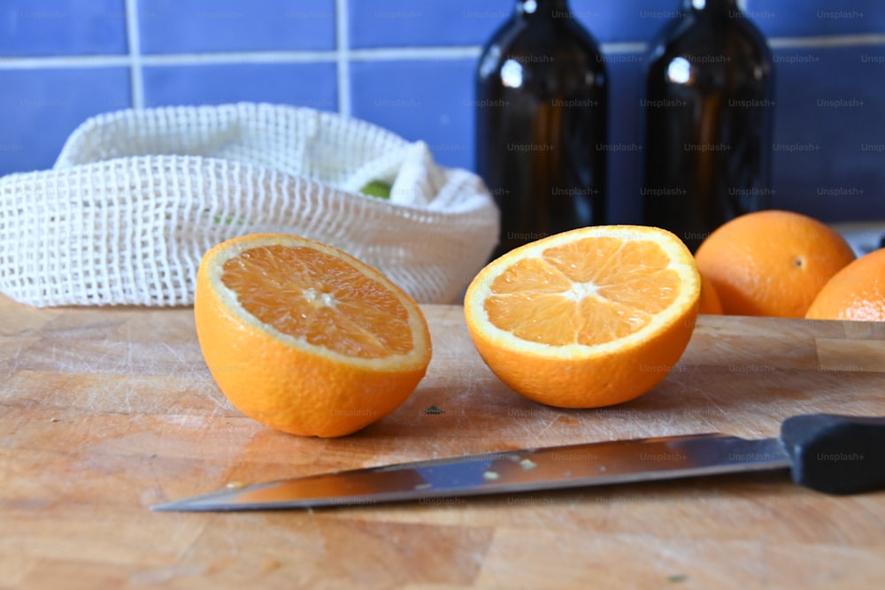 une planche à découper surmontée d’oranges et d’un couteau
