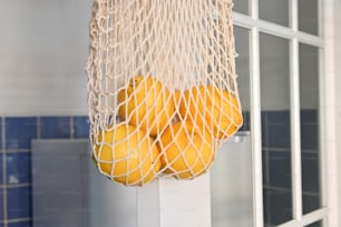 a bag full of oranges hanging from a door