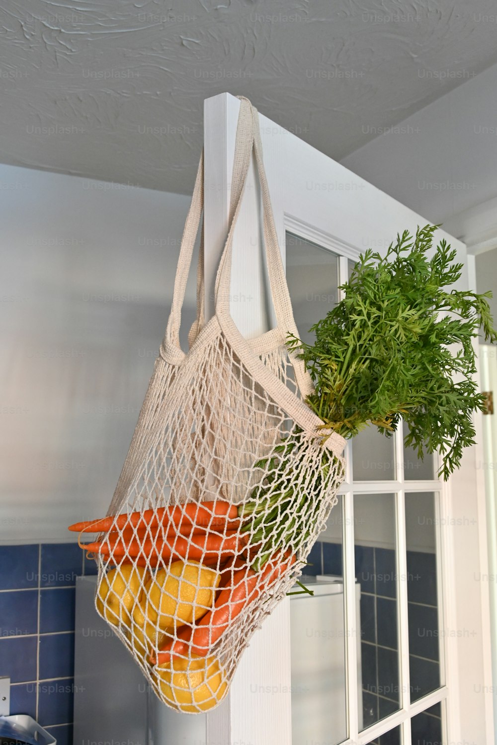 una bolsa de verduras colgando de un gancho