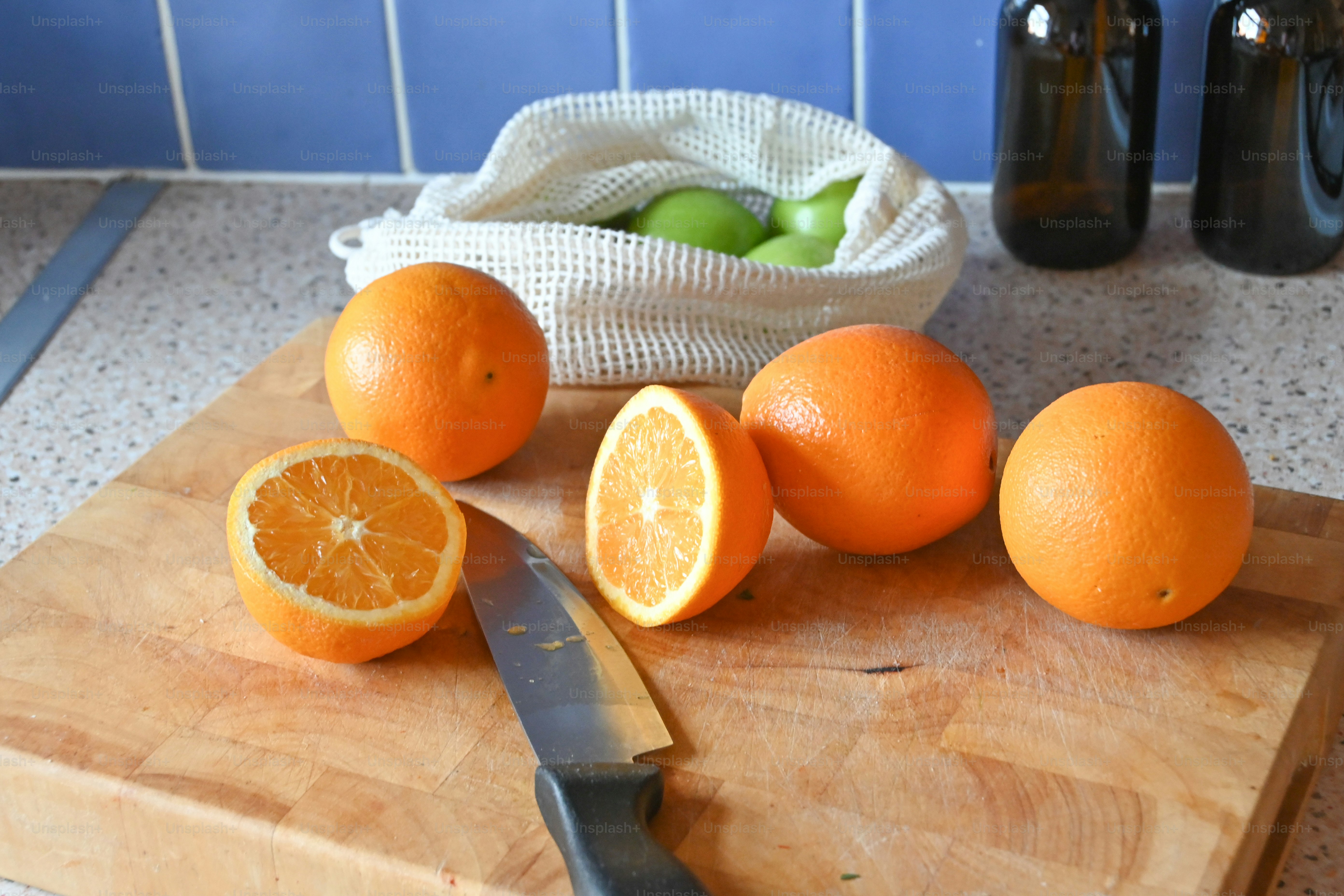a cutting board topped with oranges and a knife