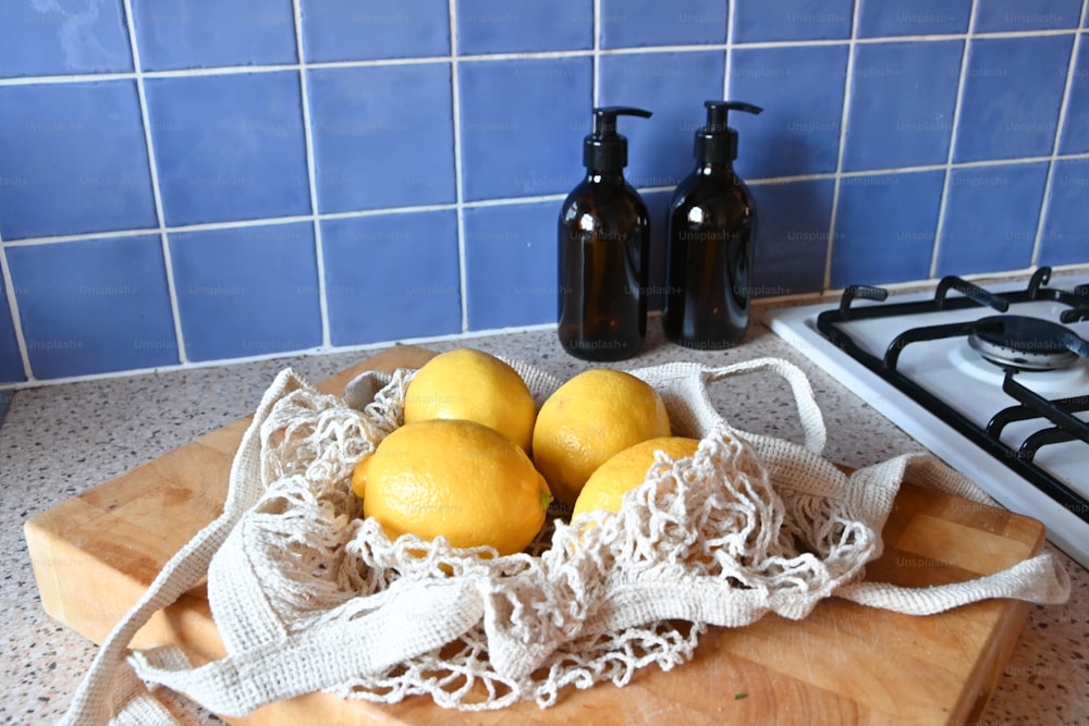 a wooden cutting board topped with lemons on top of a counter
