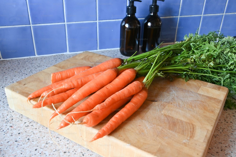 un mazzo di carote sedute su un tagliere