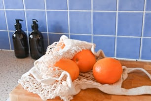 a wooden cutting board topped with oranges on top of a counter