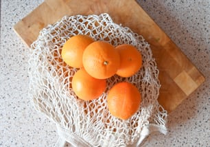 a bunch of oranges sitting on top of a wooden cutting board