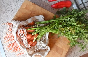 a bunch of carrots sitting on top of a wooden cutting board